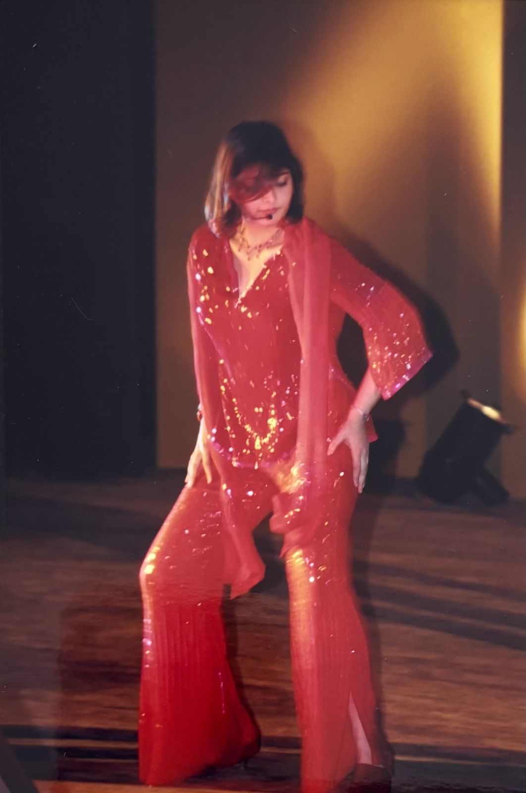 Vasundhara Das on stage in a shimmering red ensemble.