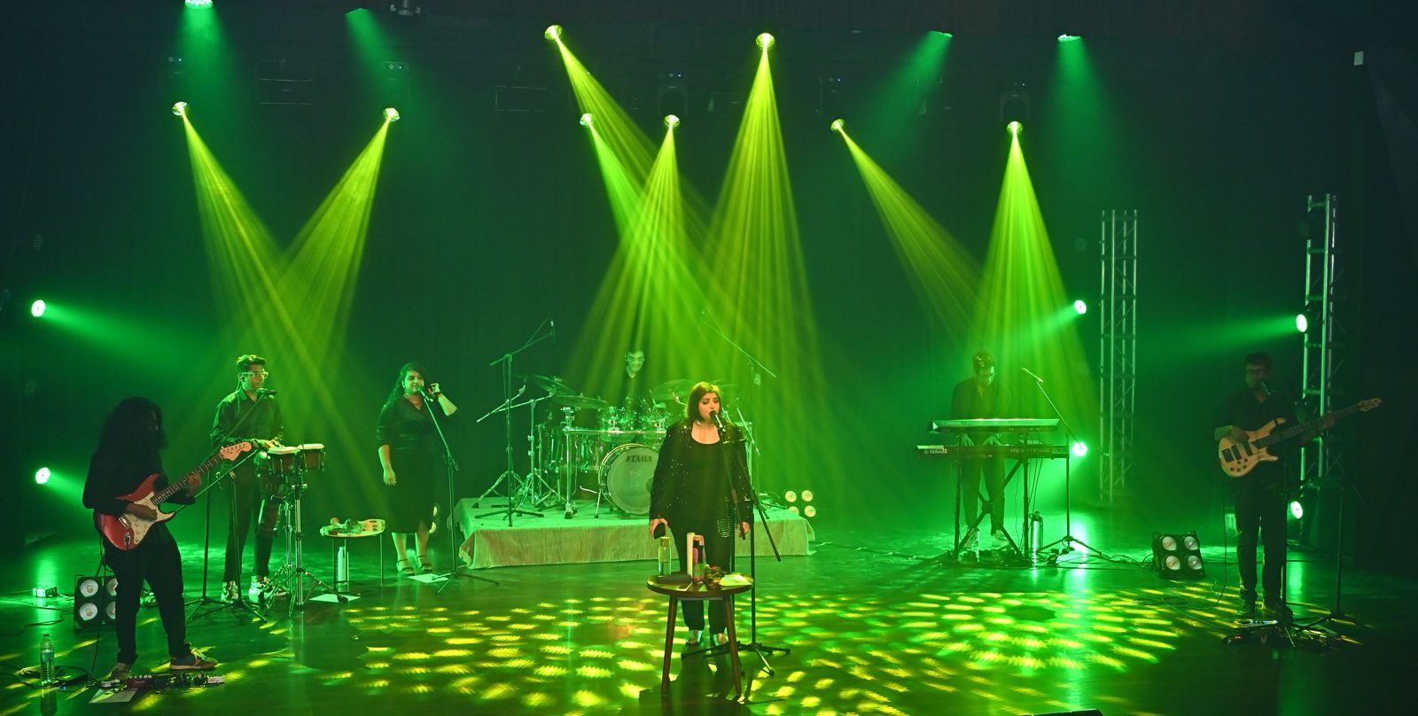 Full band performance bathed in green stage lighting.
