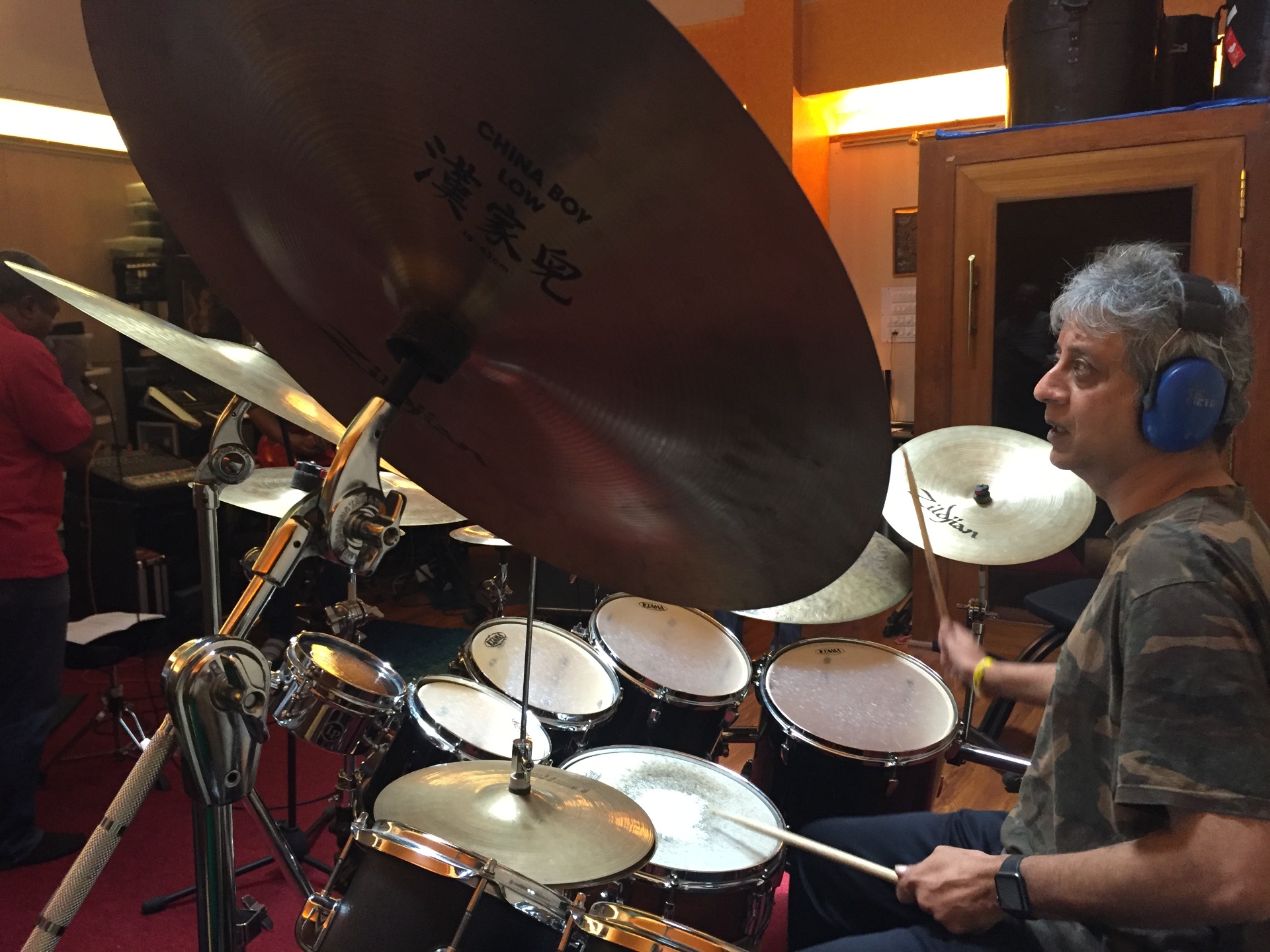 Close-up of Roberto behind a large China Boy Low cymbal in the studio.